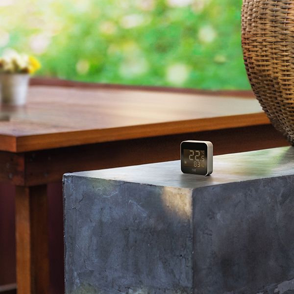 Das Eve Weather auf einem Steinblock, dabei ist im Hintergrund der Gartentisch ersichtlich