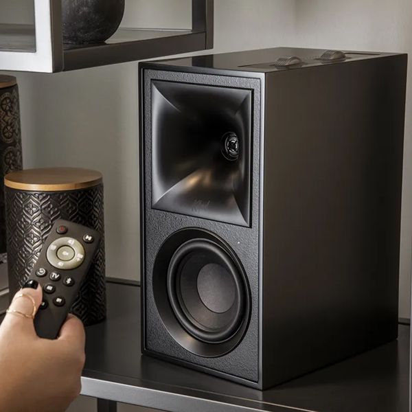 Lifestyle Bild vom Klipsch-Lautsprecher The Fives der mit der Fernbedienung gesteuert wird