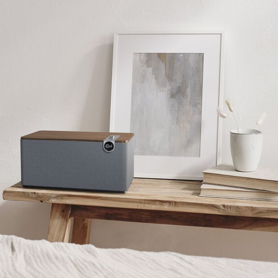 Ein Klipsch Premium Bluetooth Speaker auf einem Holztisch mit Dekorationen