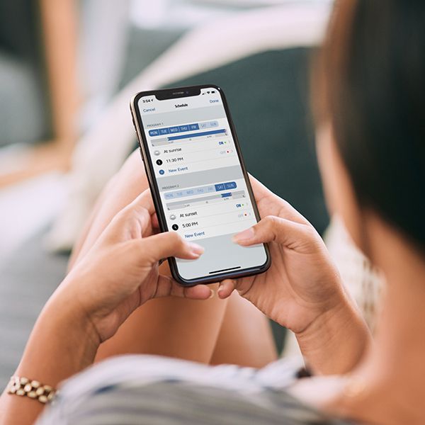 Frau mit iPhone in der Hand, dabei ist die App ersichtlich