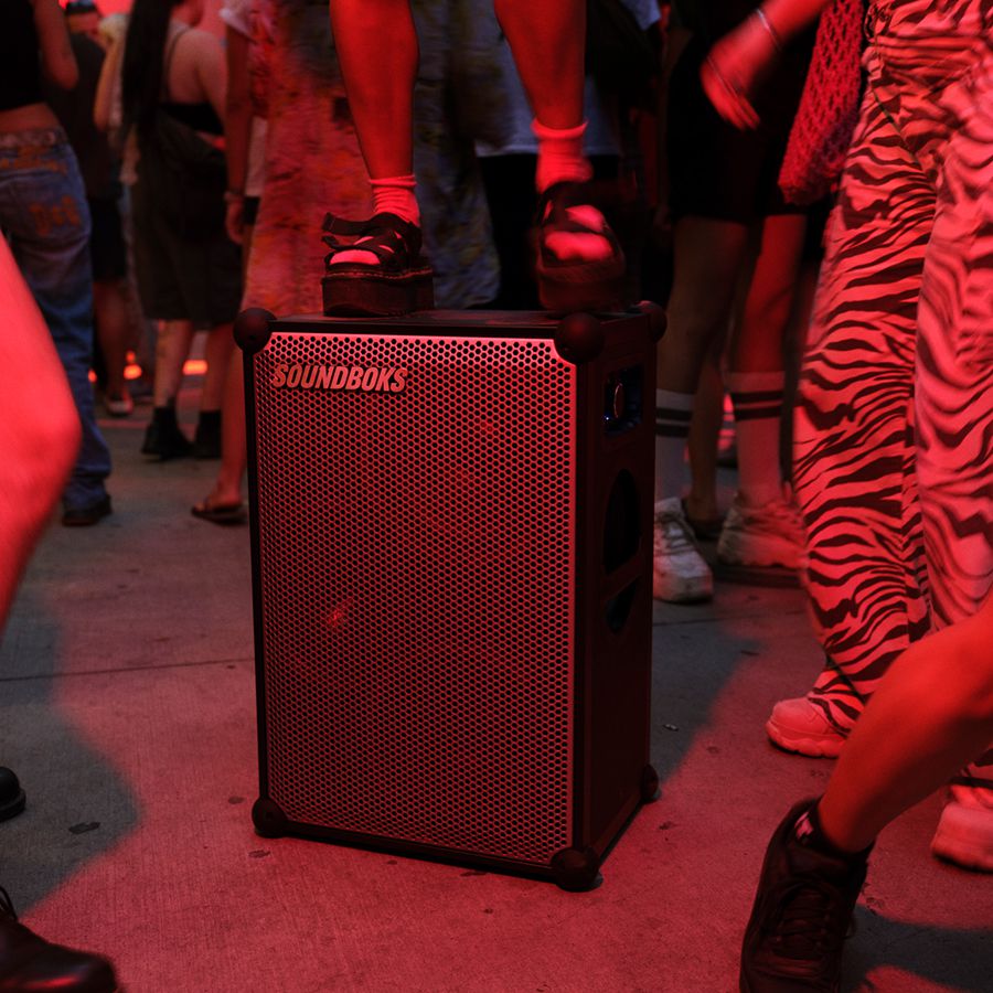 Soundboks 4 Lautsprecher steht auf dem Boden darüber schimmert ein rötliches Licht