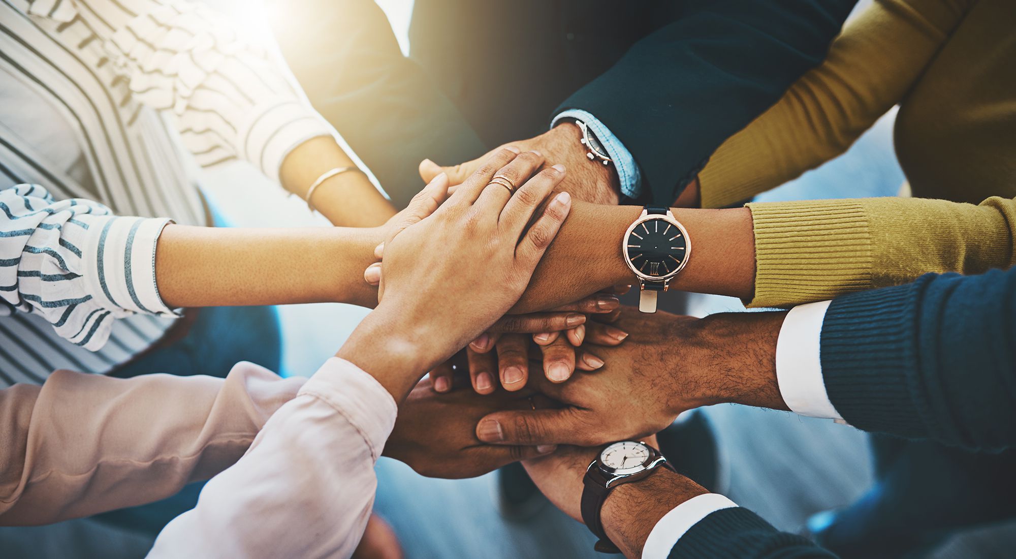 Several people shake hands as a sign of Team Work