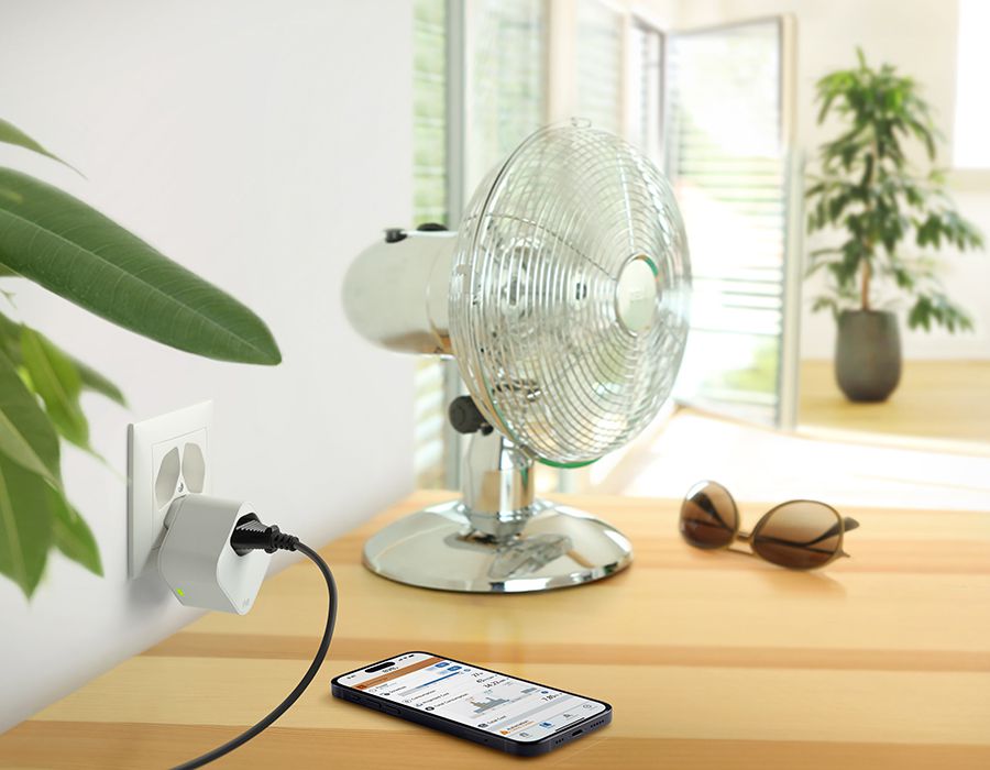Eine Darstellung der Eve Energy Steckdose mit einem Handy auf der die App zu sehen ist