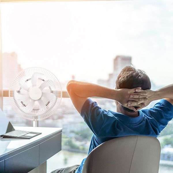 Mann am Schreibtisch neben einem Kamome Ventilator